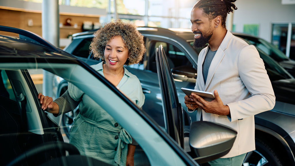 Acheteur examinant carrosserie voiture avant enchères automobiles